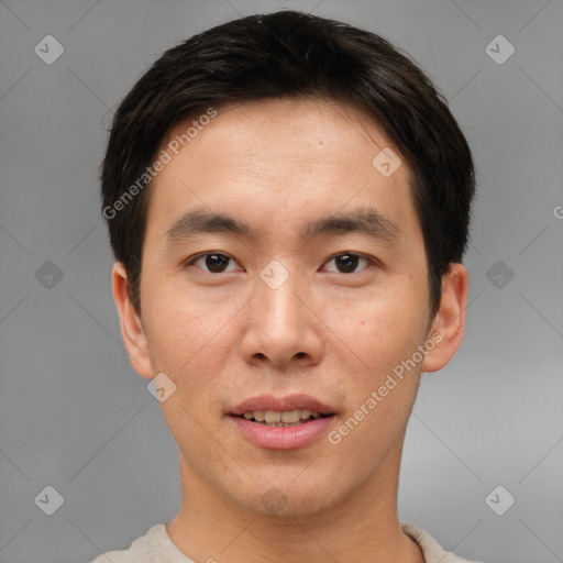 Joyful asian young-adult male with short  brown hair and brown eyes