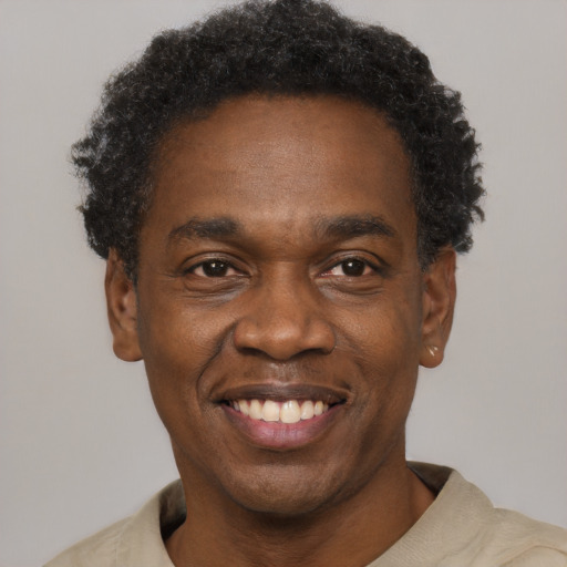 Joyful black adult male with short  black hair and brown eyes
