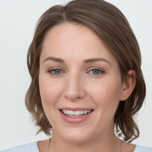 Joyful white young-adult female with medium  brown hair and grey eyes