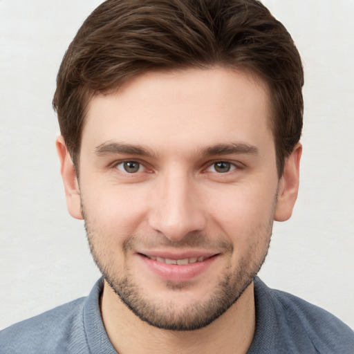 Joyful white young-adult male with short  brown hair and grey eyes