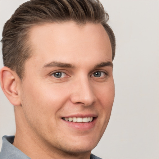 Joyful white young-adult male with short  brown hair and grey eyes