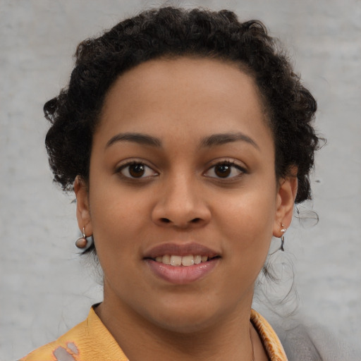 Joyful black young-adult female with short  brown hair and brown eyes