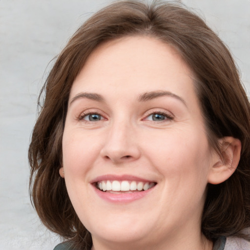 Joyful white young-adult female with medium  brown hair and blue eyes