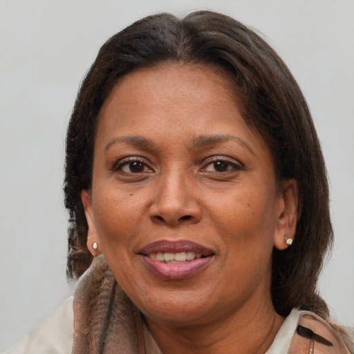 Joyful latino adult female with medium  brown hair and brown eyes