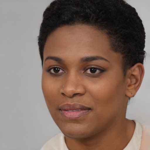 Joyful black young-adult female with short  black hair and brown eyes