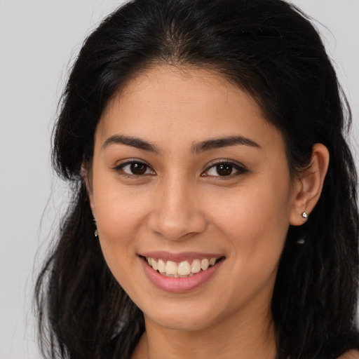 Joyful latino young-adult female with long  brown hair and brown eyes