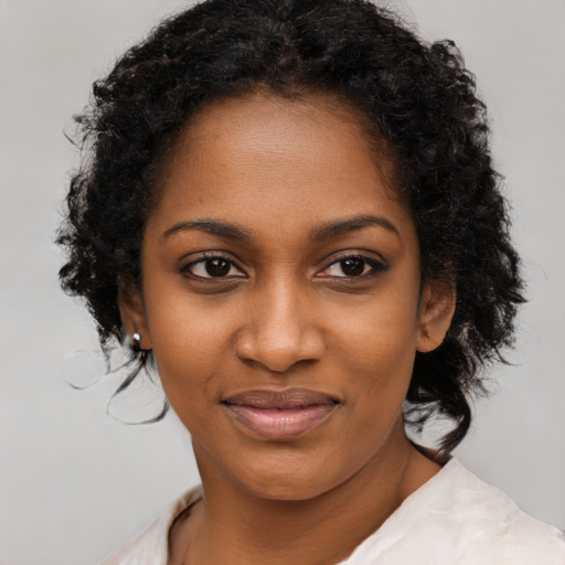 Joyful black young-adult female with long  brown hair and brown eyes