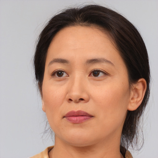 Joyful asian adult female with medium  brown hair and brown eyes