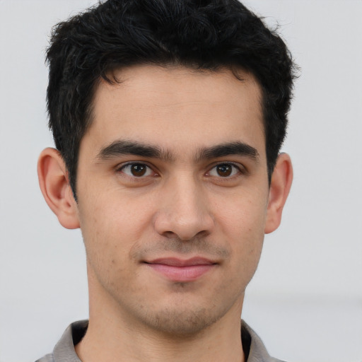 Joyful latino young-adult male with short  brown hair and brown eyes