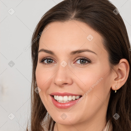 Joyful white young-adult female with long  brown hair and brown eyes