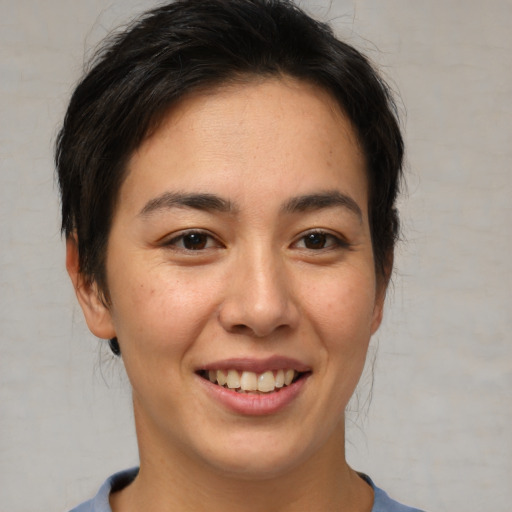 Joyful asian young-adult female with short  brown hair and brown eyes