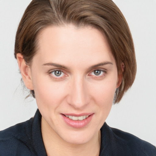 Joyful white young-adult female with medium  brown hair and grey eyes