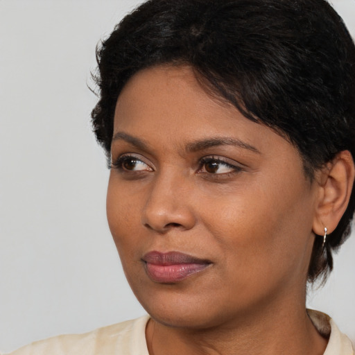 Joyful black young-adult female with short  brown hair and brown eyes