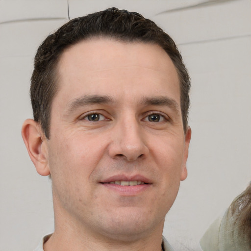 Joyful white adult male with short  brown hair and brown eyes