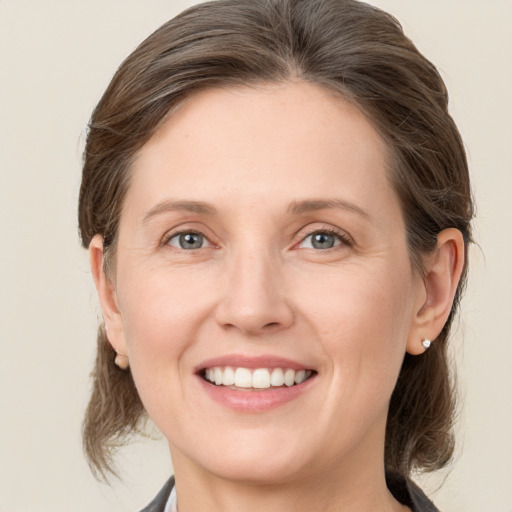 Joyful white young-adult female with medium  brown hair and blue eyes