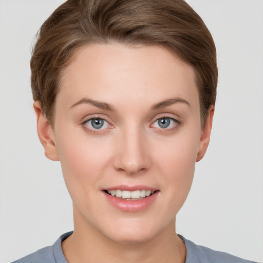 Joyful white young-adult female with short  brown hair and grey eyes