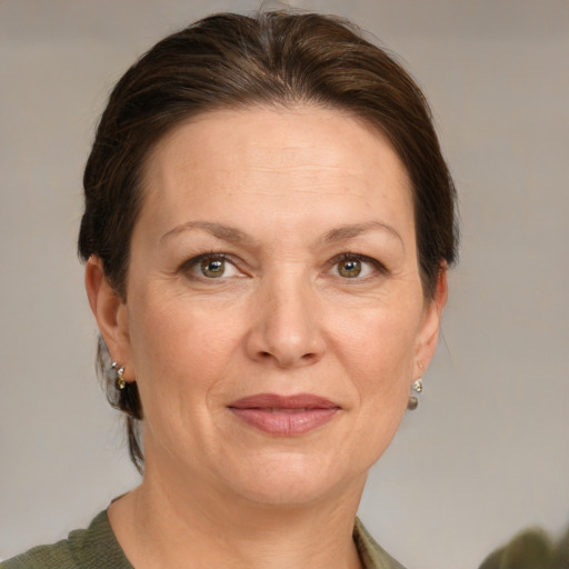 Joyful white adult female with medium  brown hair and grey eyes