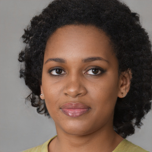 Joyful black young-adult female with medium  black hair and brown eyes