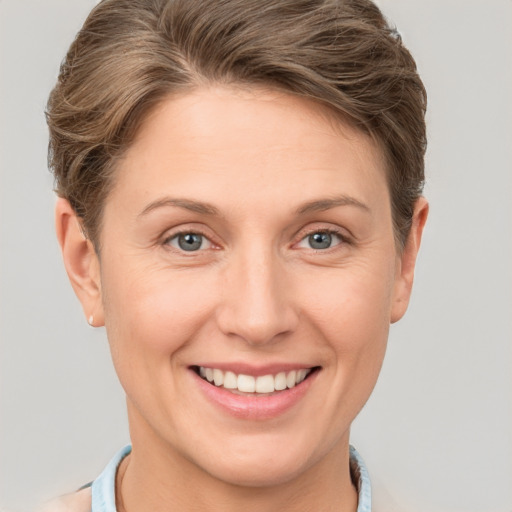 Joyful white adult female with short  brown hair and grey eyes