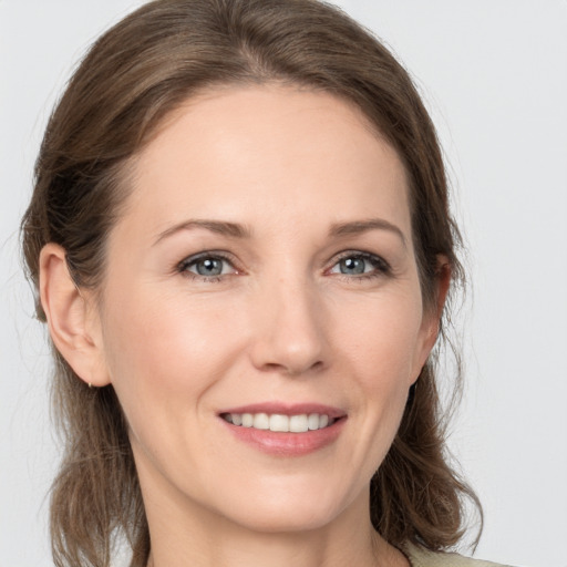 Joyful white young-adult female with medium  brown hair and grey eyes