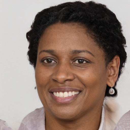Joyful black adult female with short  brown hair and brown eyes