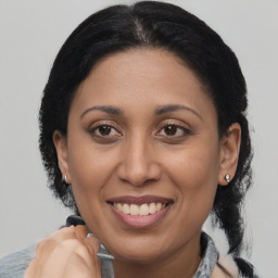 Joyful latino adult female with medium  brown hair and brown eyes