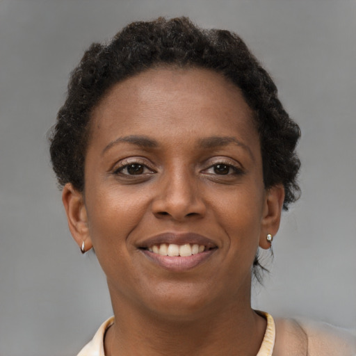 Joyful black young-adult female with short  brown hair and brown eyes