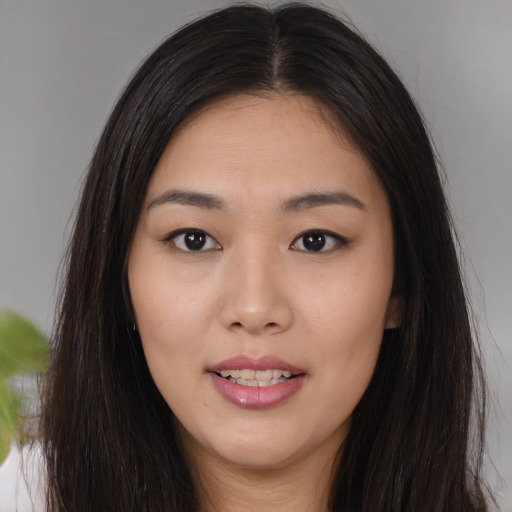 Joyful asian young-adult female with long  brown hair and brown eyes