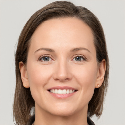 Joyful white young-adult female with medium  brown hair and grey eyes