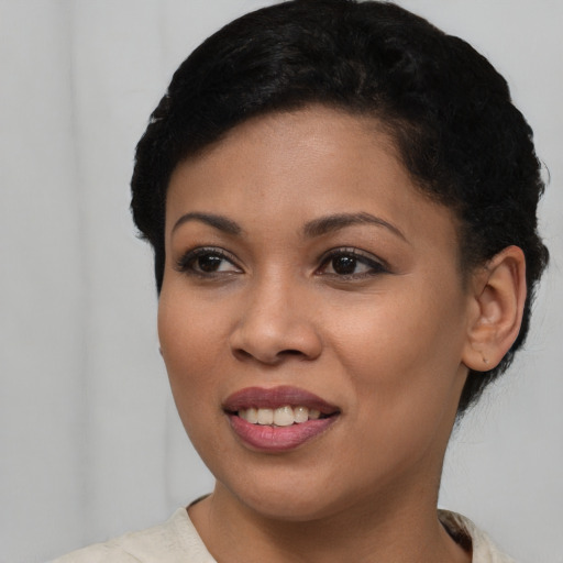 Joyful black young-adult female with short  brown hair and brown eyes