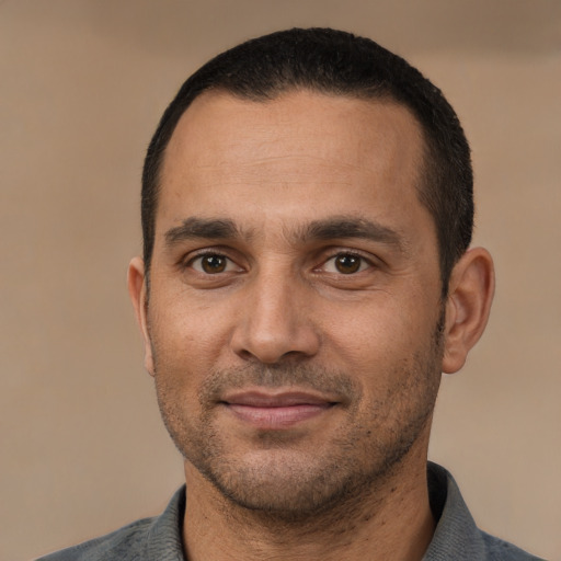 Joyful white adult male with short  black hair and brown eyes