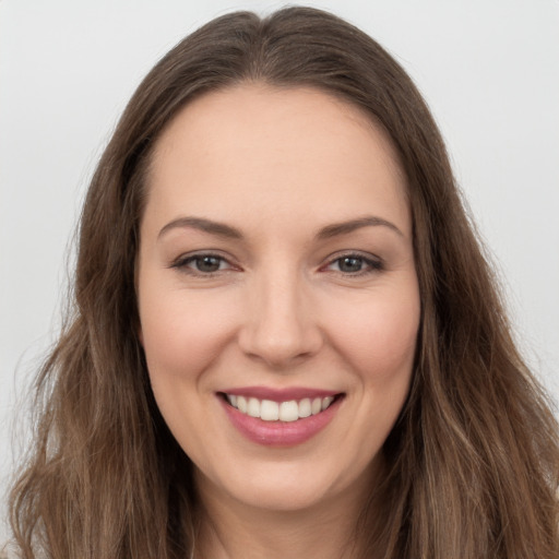 Joyful white young-adult female with long  brown hair and brown eyes