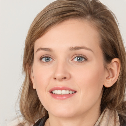 Joyful white young-adult female with medium  brown hair and grey eyes