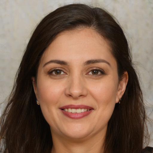Joyful white adult female with long  brown hair and brown eyes
