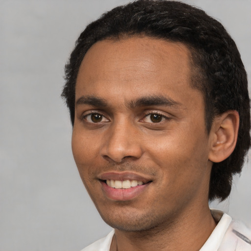 Joyful black young-adult male with short  black hair and brown eyes