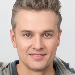 Joyful white young-adult male with short  brown hair and grey eyes