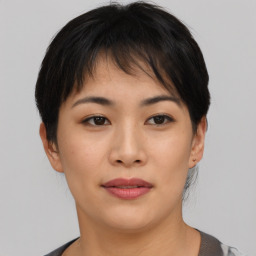 Joyful asian young-adult female with short  brown hair and brown eyes