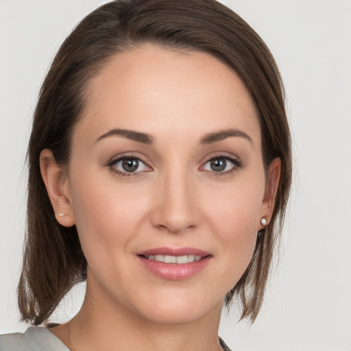 Joyful white young-adult female with medium  brown hair and grey eyes