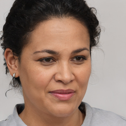 Joyful latino adult female with medium  brown hair and brown eyes