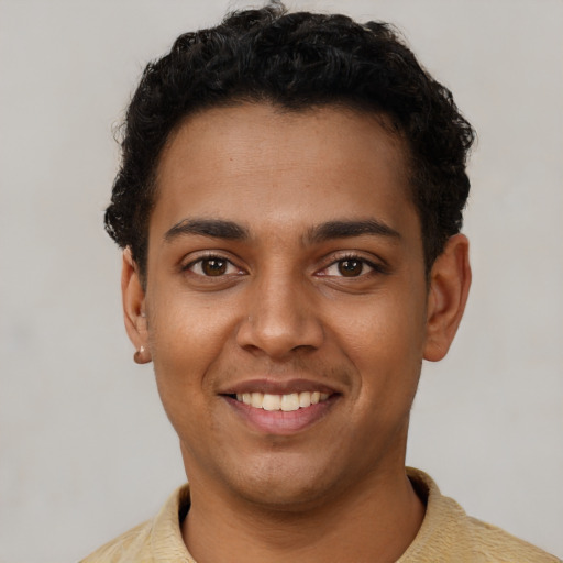 Joyful latino young-adult male with short  brown hair and brown eyes