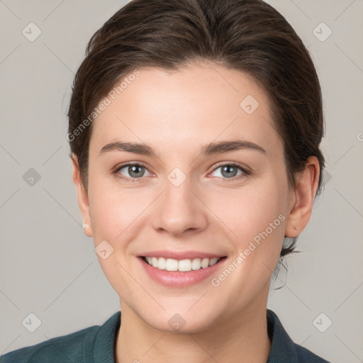 Joyful white young-adult female with medium  brown hair and grey eyes