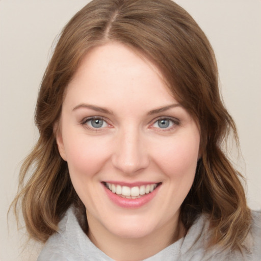 Joyful white young-adult female with medium  brown hair and blue eyes