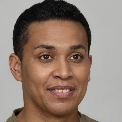 Joyful latino young-adult male with short  brown hair and brown eyes