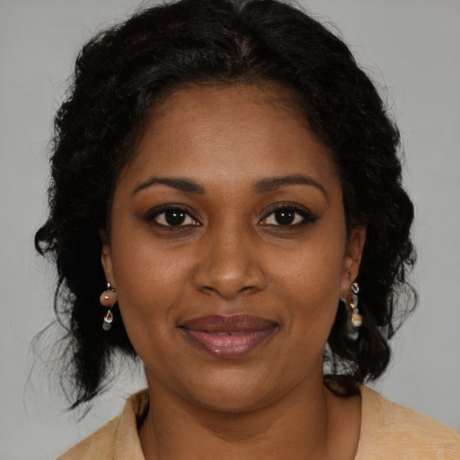 Joyful black adult female with medium  brown hair and brown eyes