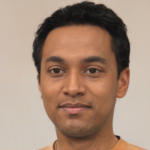 Joyful latino young-adult male with short  black hair and brown eyes