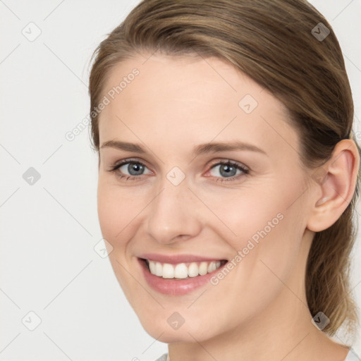 Joyful white young-adult female with long  brown hair and grey eyes