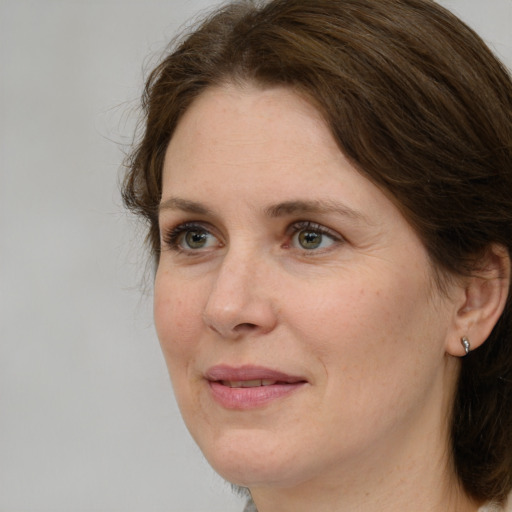 Joyful white adult female with medium  brown hair and green eyes