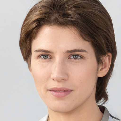 Joyful white young-adult female with medium  brown hair and grey eyes