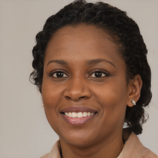 Joyful black young-adult female with medium  brown hair and brown eyes