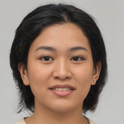 Joyful asian young-adult female with medium  brown hair and brown eyes